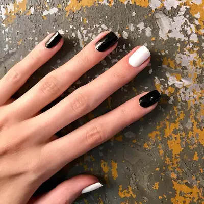 Short square-shaped nails with four black nails and one white middle finger