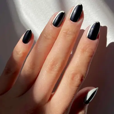 Rounded black nails with curvy white line on the left edge