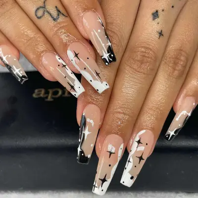 Nude black-and-white rectangular nails with puffy cloud and star motifs