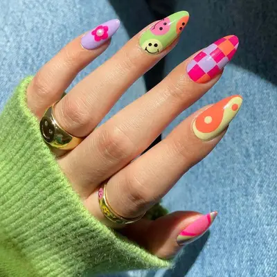 Cheerful pink, purple, green, and orange nails with checkerboard and smiley prints.
