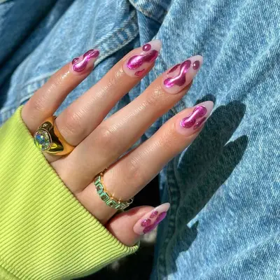 Hand with pink chrome nail art and rings