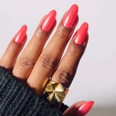 Manicure with glossy nail polish and a gold geometric ring