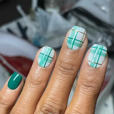 Ultra-short coffin nails with green and white plaid design and solid green accent nail