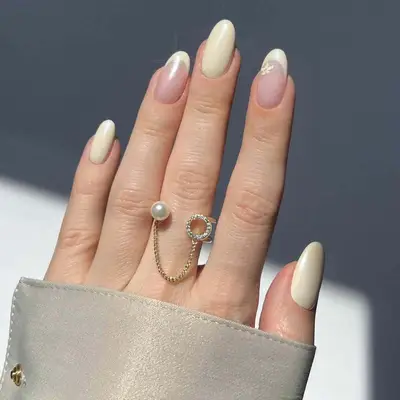 Vanilla-toned manicure with chrome French accent nails and micro flower design