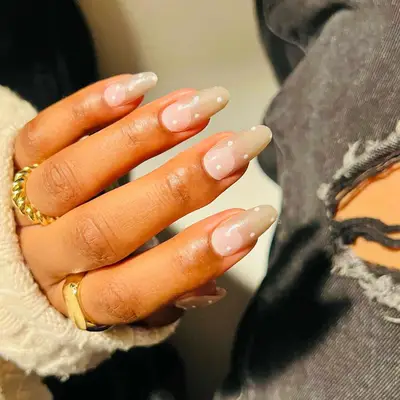 Vanilla chrome nails with negative space cuticle half-moon and white polka dots