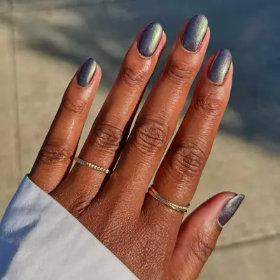 model with iridescent green and steel nails