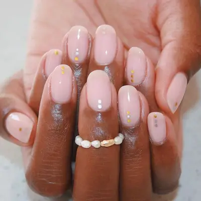 Pale pink manicure with small gold and silver dotted lines