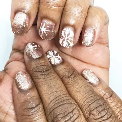 Champagne glitter manicure with snowflake designs
