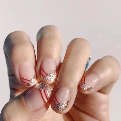 Clear manicure with half-silver sparkle, half-red stripe tip