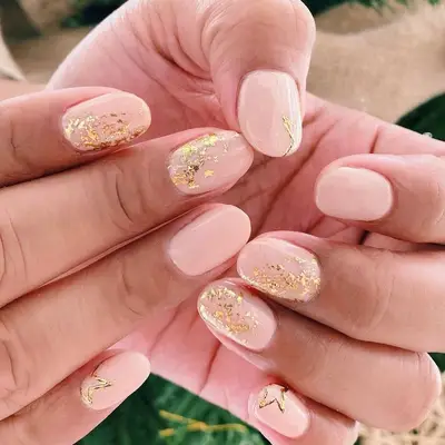 Peachy nude nails with gold dust and star outline detailing
