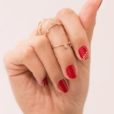 Red manicure with flecked gold accent