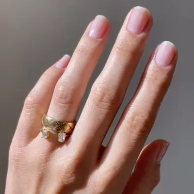 Neutral milky nails with thin stark cream-colored French tips