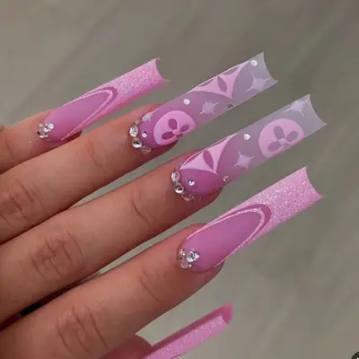 Matte pink Louis Vuitton patterned nails with glitter French tips and gemstone cuticles