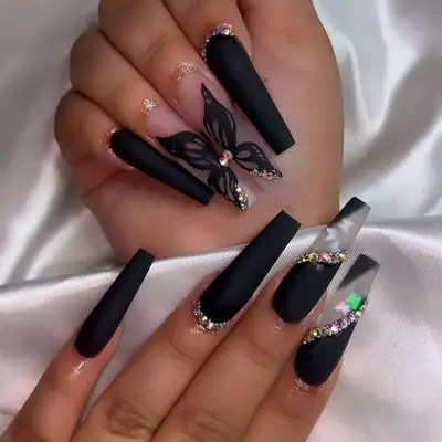 Matte black nails with butterfly designs and gemstones