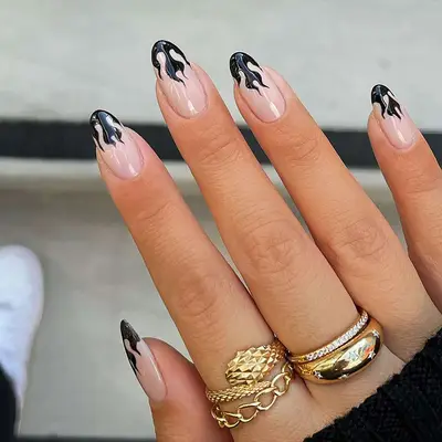 a black french manicure with flame tips
