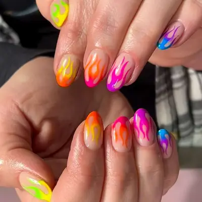 a french manicure with rainbow ombré flame tips