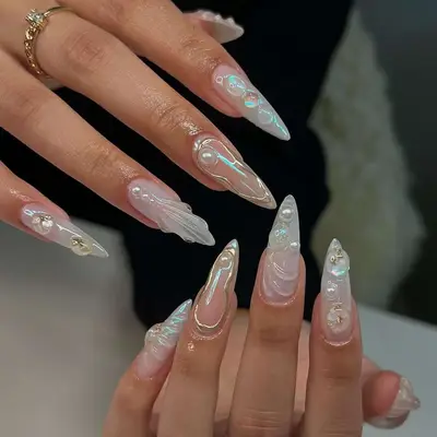 Pearlescent acrylic nails with 3D sculpted details, pearls, and gold accents