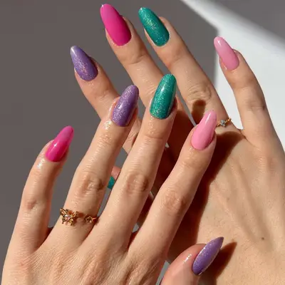 Manicure with hot pink, pastel pink, lavender, and teal shimmer polishes