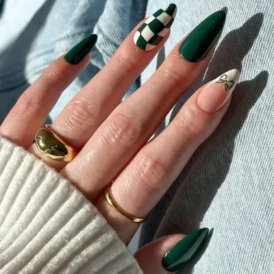 manicure with green christmas nails, one nail white and green checkers, one nail white french tip with green bow