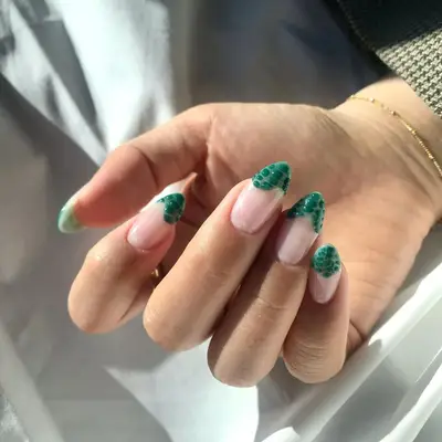 a manicure with wavy croc emerald green french tips