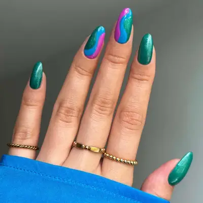 an emerald green manicure with swirls in fuchsia and blue