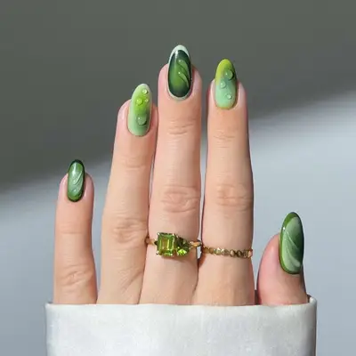a mismatched green aura manicure with builder gel accents