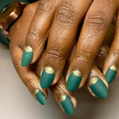 an emerald green matte mani with gold foil cuticle tips