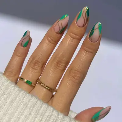 a negative space manicure with green and gold accents