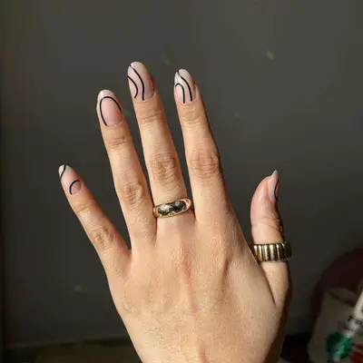 nude manicure with abstract black wavy lines