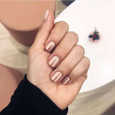 cream manicure with gold lines