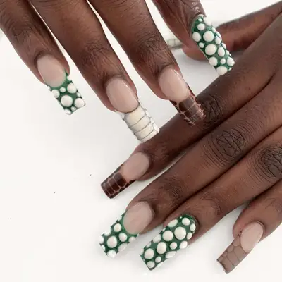A manicure in shades of brown and white croc print and green and white 3D bubbles