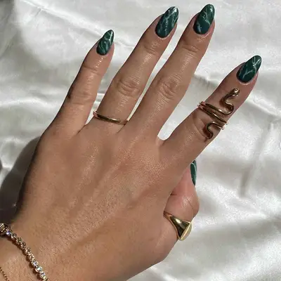 Malachite green nails against a white backdrop