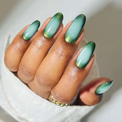 An evergreen and baby blue aura manicure