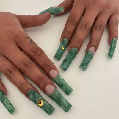 Two hands with a jade green manicure