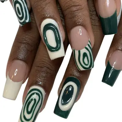A manicure with dark green French tips and white nails with dark green details
