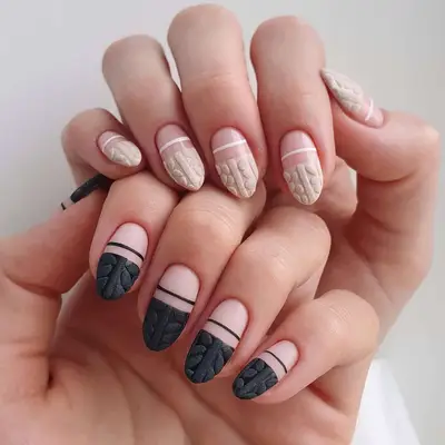Close-up of sweater manicure with one in nude color and one in black