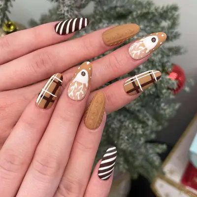 Close-up of brown manicure with sweater design, plaid, reindeer head design, and brown and white candy cane stripe