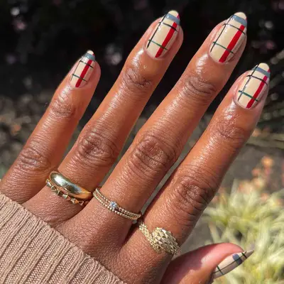 Close-up of beige, blue, and green plaid nail design