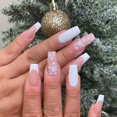 Close-up of white manicure with glitter knit detail, snowflake pattern, and French tips