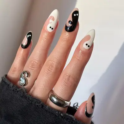 Negative space manicure with small white ghosts.