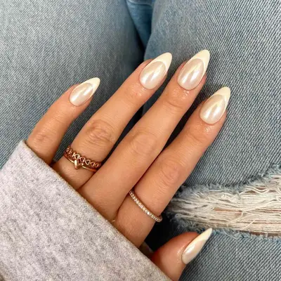 Close view of manicured hands with pointed nails, light design, and casual clothing