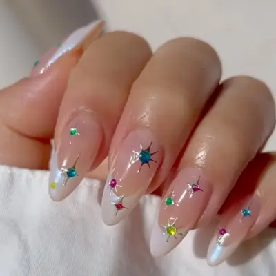 A hand displaying long nails with a glossy finish and colorful gem embellishments