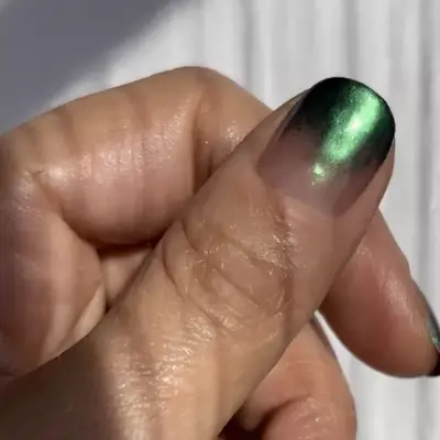 Thumb with forest green chrome ombre manicure