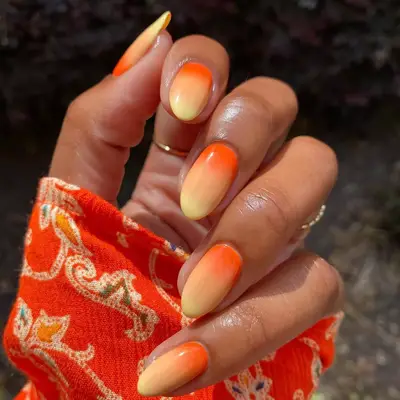 Hand with an orange-to-yellow gradient manicure