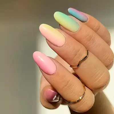 Hand with a horizontal pastel rainbow gradient manicure