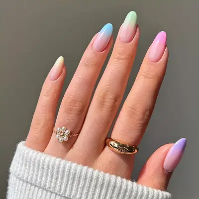 Hand with a multicolored pastel ombre manicure
