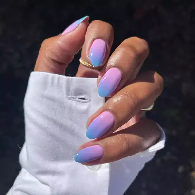 Hand with pink and blue gradient ombre nails