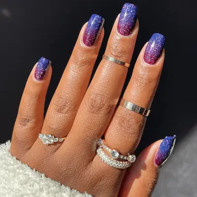 Square-shaped nails with red and blue gradient and glittery overlay