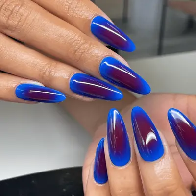 Long almond-shaped nails with red and blue aura mani