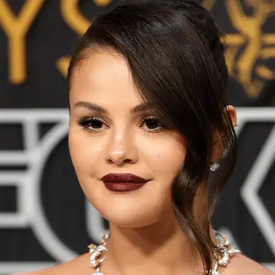 Selena Gomez at the 2024 Emmys, wearing a dark vampy red lip